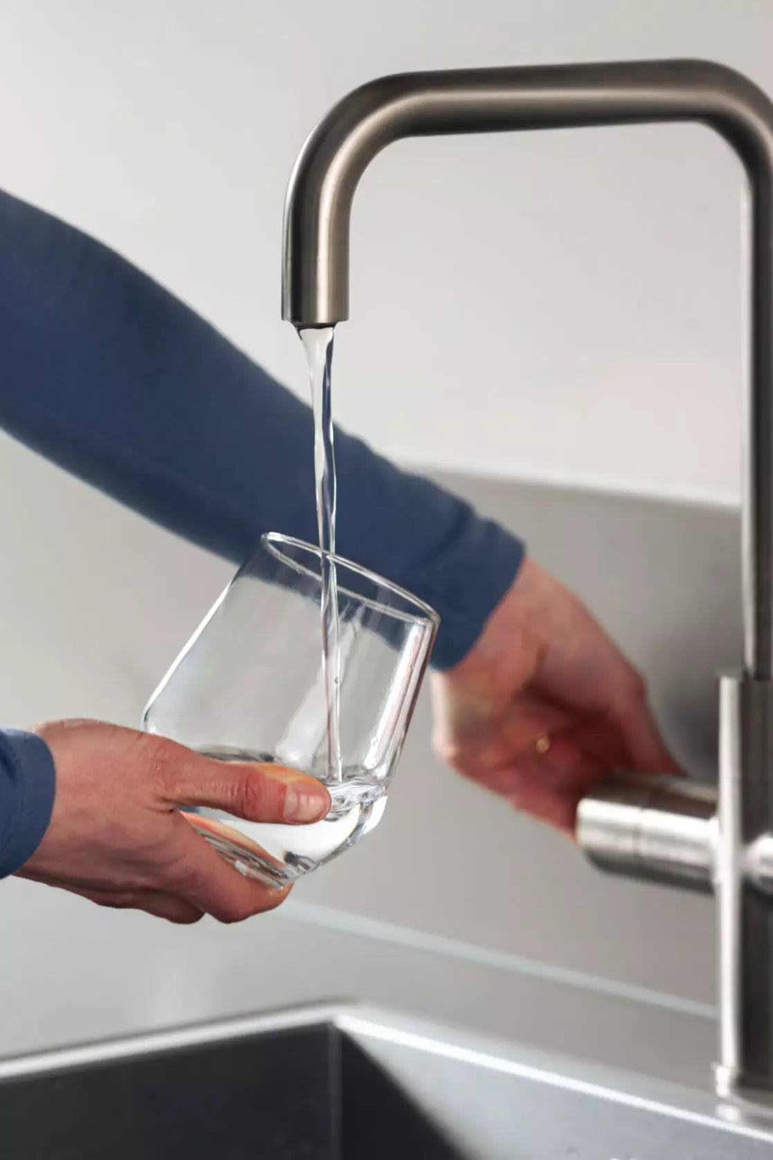 Zuiverwater wat uit de kraan stroomt in een glas