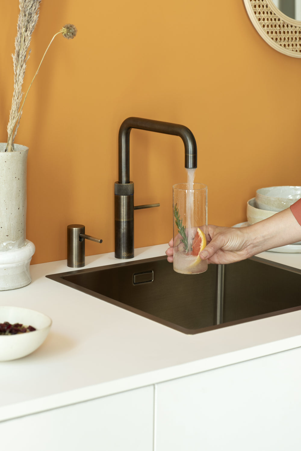 Quooker zeeppompje naast een Quooker kraan in een moderne keuken, ideaal voor zeep of lotion.