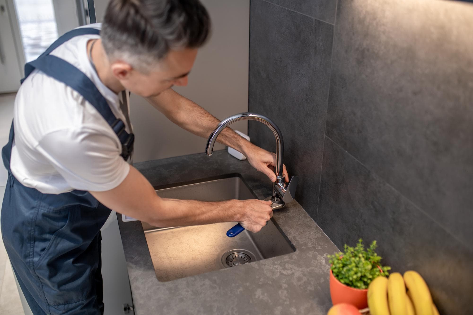 Gecertificeerde installateur plaatst een PureAqua kraan in een moderne keuken
