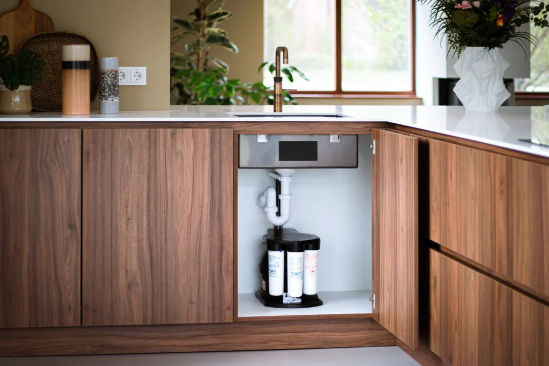 Waterfilter voor thuis van PureAqua onder het aanrecht geïnstalleerd — omgekeerde-osmosesysteem in een walnoot keukenkast