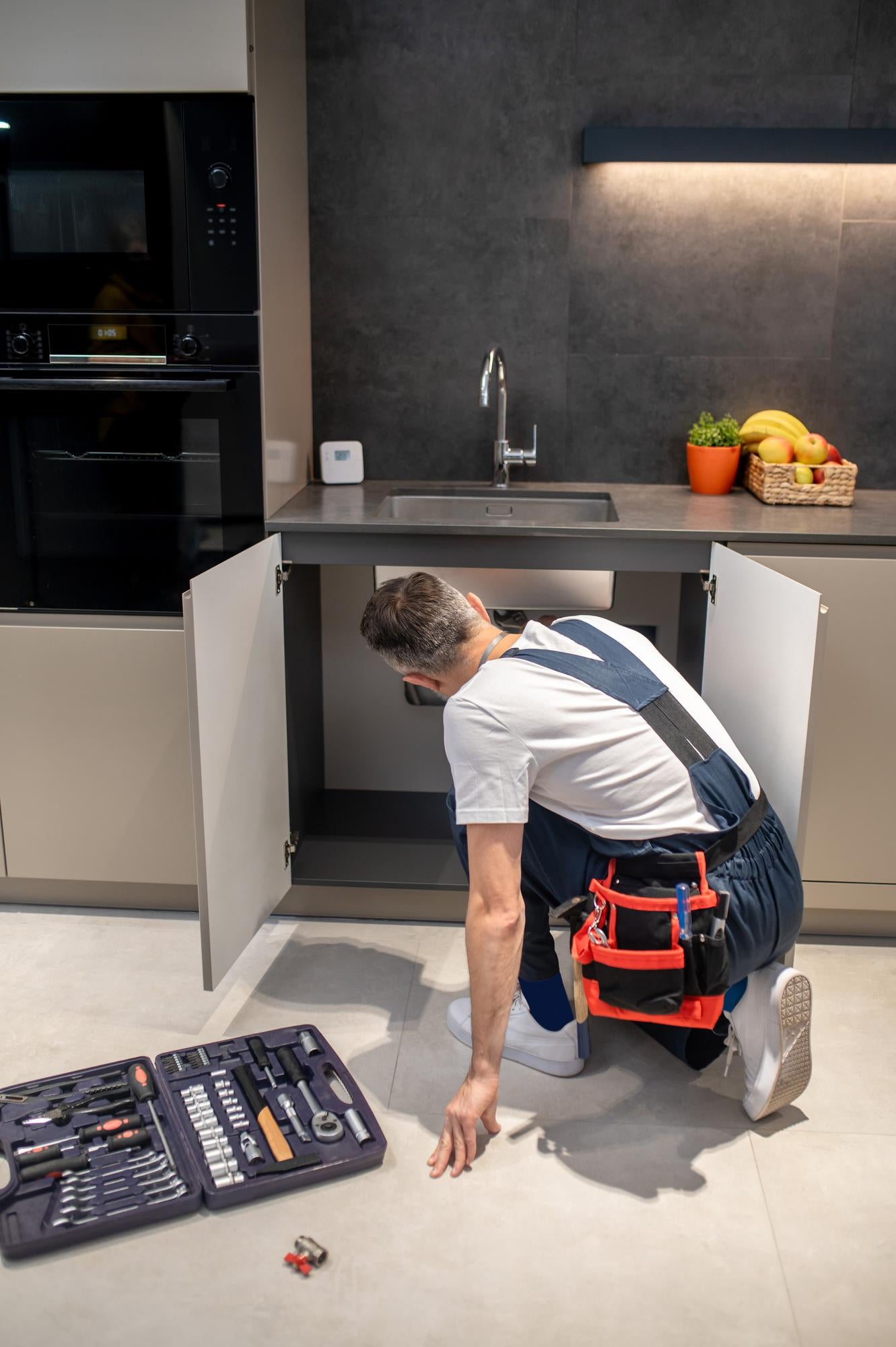 PureAqua monteur is bezig met het installeren van een quooker zeepdispenser 
