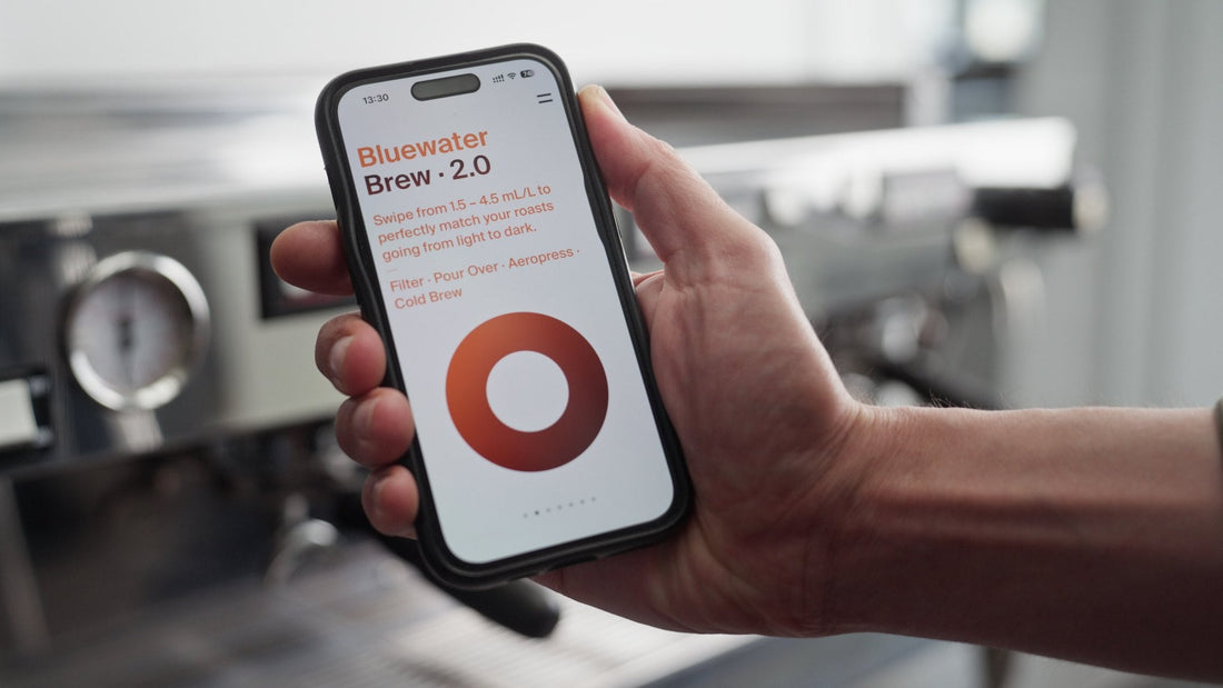 Bluewater Brew app on a phone beside an espresso machine