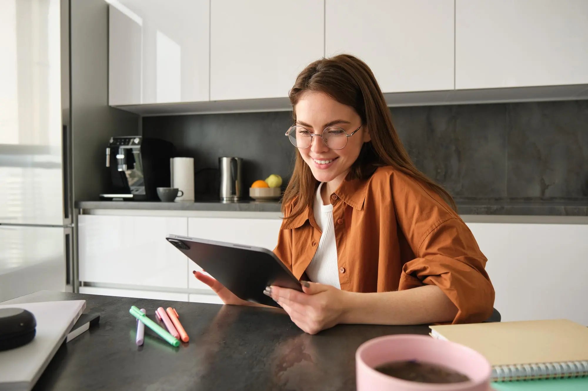Vrouw in moderne keuken kiest installatiedatum voor PureAqua zuiverwaterkraan via tablet