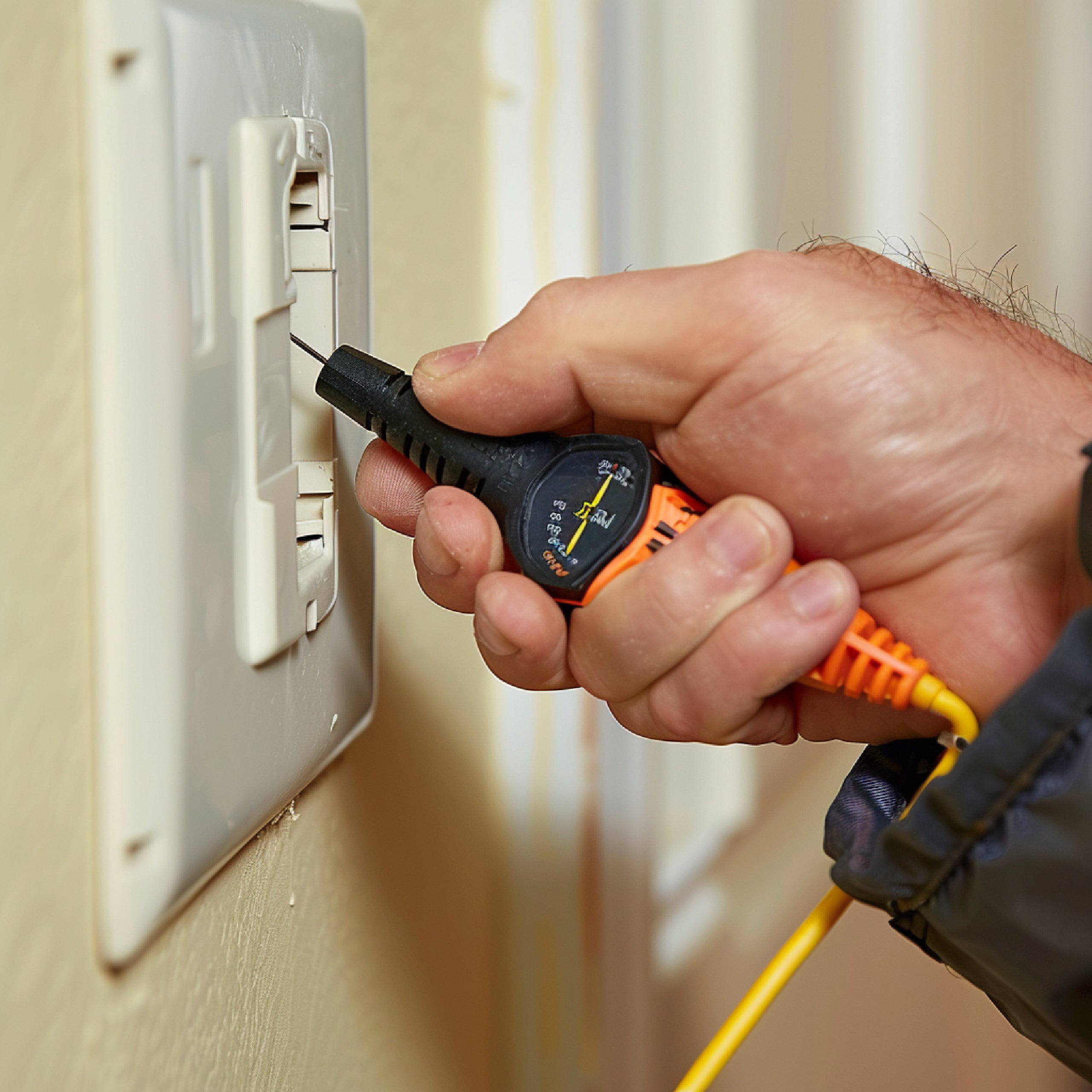 Man test stopcontact tijdens stroomstoring – symbool voor noodsituaties waarin waterfiltersystemen thuis essentieel worden voor veilig drinkwater.