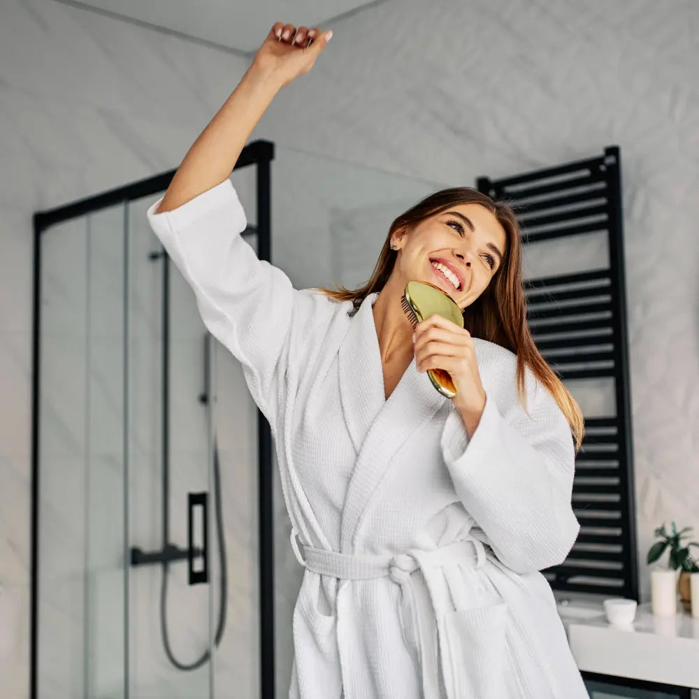 Vrouw geniet van zacht water na het douchen, bij de uitleg over hoe werkt een waterontharder van PureAqua